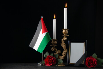 front view burning candles with palestinian flag and picture frame dark background death