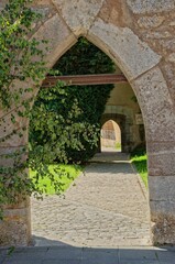 Fototapeta na wymiar a stone archway in the middle of a walkway leading to a garden