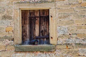 Pigeons cuddling on a window of an aged stone building in Rothenburg ob der Tauber