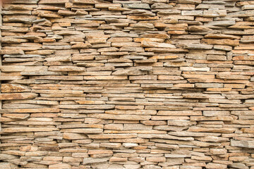 House garden stone wall made of sandstone slabs closeup as stone background