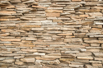 House garden stone wall made of sandstone slabs closeup as stone background