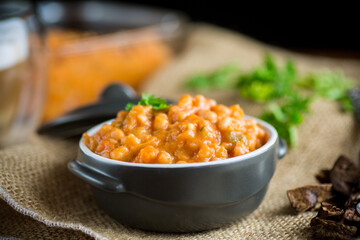 beans stewed with vegetables and spices, in a bowl .