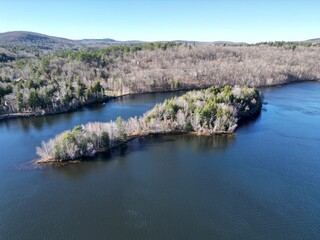 Obraz premium Areal view of a tranquil lake in New Hampshire, surrounded by lush green trees set in a wooded area