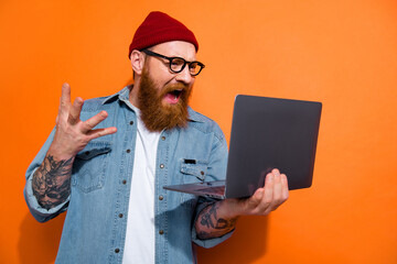 Photo of angry screaming man wear jeans shirt spectacles having working problem gadget empty space isolated orange color background - obrazy, fototapety, plakaty