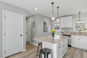 Modern kitchen with white walls and cabinets, featuring stainless steel appliances