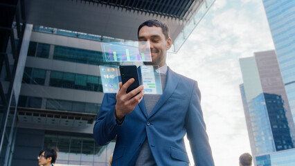 On Busy City Street Handsome Businessman Uses Smartphone with Edited Visual Holographic Screens Show Business Graphs, Charts and Stock and Crypto Market Analysis Statistics. Mock-up Mobile OS UI/UX. - obrazy, fototapety, plakaty