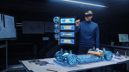 Automotive Engineer Wearing VR Headset Working on 3D Electric Car Design, Using Gestures in...