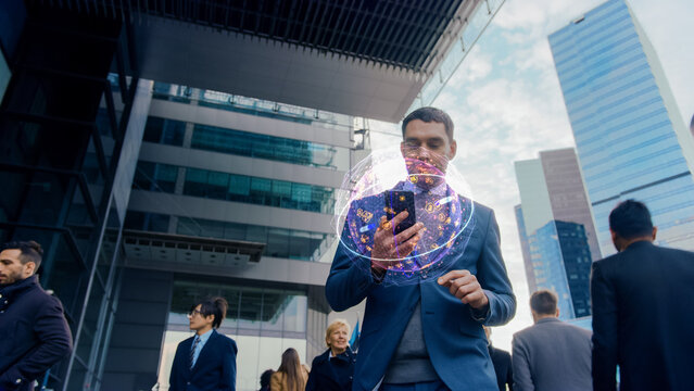 Handsome Businessman Uses Smartphone with Visual Infographics Showing Internet Icons, Walks through Crowded Megapolis City Streets. Connection, Big Data, Information, e-Business Concept.