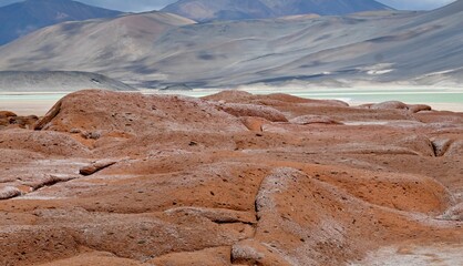 Tranquil body of water seen through red rocks in Atacama Desert Salt Flats in Chile