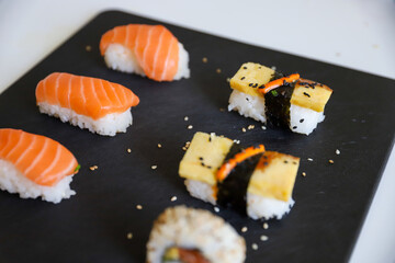close up of sushi set on dark tray