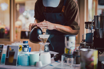 Barista pouring hot water to make drip coffee.