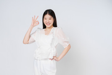 Portrait of young woman smiling and showing ok sign isolated on white background.