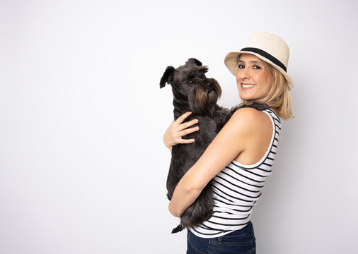 Cute Young Woman Hugs Her Puppy Schnauzer Dog. Love Between Owner And Dog. Isolated On White Background. Studio Portrait.