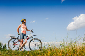 Mountain biking - woman with bike enjoy summer vacation