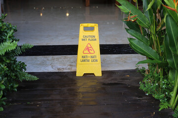 yellow warning slippery wet floor on wooden floors and granite floors