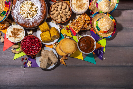 Traditional Festa Junina Summer Festival Carnival Food. Traditional Brazilian Festa Junina dishes and snacks - popcorn, peanuts, corn cake and cookie, pacoca, with holiday decorations and accessories