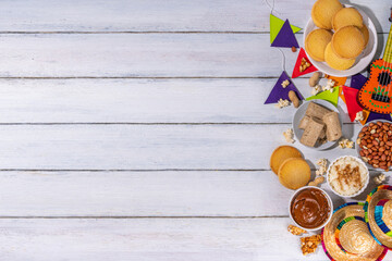 Traditional Festa Junina Summer Festival Carnival Food. Traditional Brazilian Festa Junina dishes and snacks - popcorn, peanuts, corn cake and cookie, pacoca, with holiday decorations and accessories