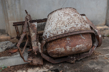 Broken Old Mortar Mixers beside the wall.