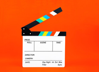 A movie clapper on orange background ; film, cinema and video photography concept.