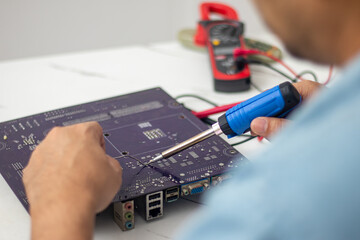 Technician using a soldering iron to repair a circuit board