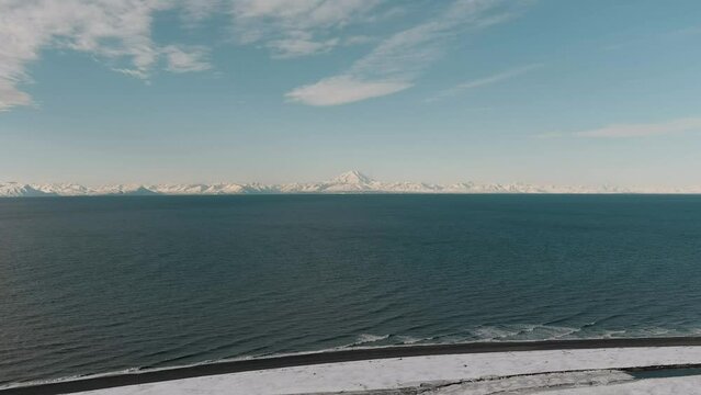 View of Mount Redoubt, Alaska in the winter with the Cook Inlet Ocean in the foreground 