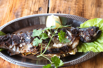 The traditional dish of Eastern Serbia - grilled mountain trout with boiled potato, garlic, lemon, parsley and olive oil
