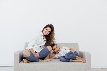 Obraz premium mother and son sit on the couch in a bright room