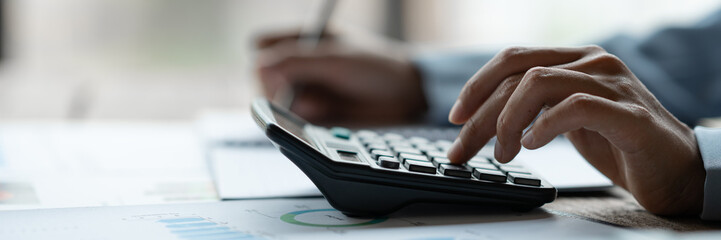 Image of hands of businesswoman, investor, pressing calculator to calculate numbers Income and...