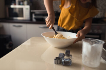 Making cookies at home, child making dough