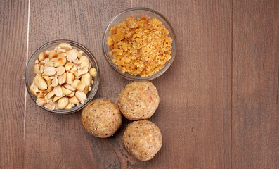 Homemade healthy and sweet groundnut or peanut and Jaggery Laddoo, delicious indian sweet served on a wooden background.Roasted peanut isolated.