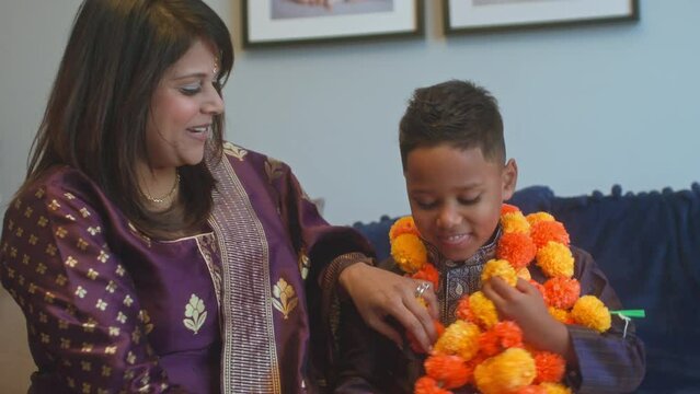 MS Mother putting Diwali flower garland on son (6-7)