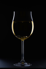 Glass of white wine on black background