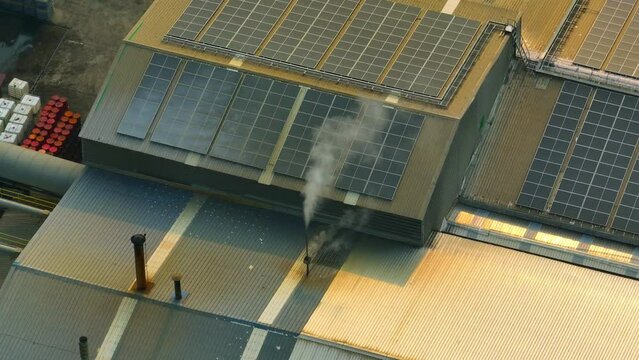 The industrial exhaust fumes contribute to global warming by releasing greenhouse gases like carbon dioxide and methane, which trap heat in the atmosphere and lead to climate change. Aerial view. 4K
