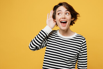 Young excited fun curious nosy woman wear casual striped black and white shirt try to hear you...