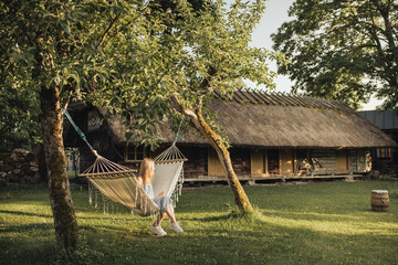Woman Swinging On A Hammock Between Trees In Beautiful Farm Yard On Island On A Beautiful Summer...