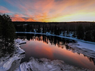 Naklejka premium Landscape of a pond surrounded by a forest during a breathtaking sunset in Hamar, Norway