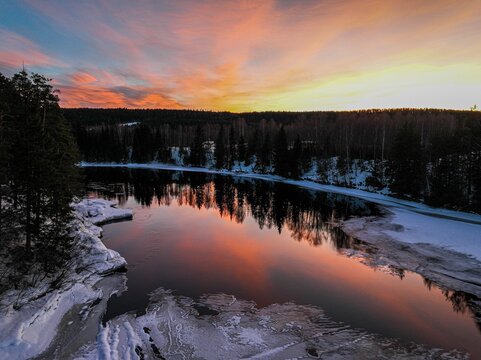 Landscape of a pond surrounded by a forest during a breathtaking sunset in Hamar, Norway