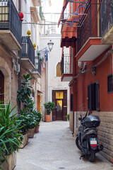 Narrow street of Bari Vecchia, houses, scooter