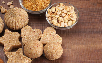 Homemade healthy and sweet groundnut or peanut and Jaggery Laddoo, delicious indian sweet served on a wooden background.Roasted peanut isolated.