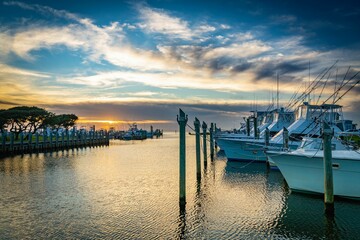 Landscape of boats docked near a pier on the sea during the sunrise