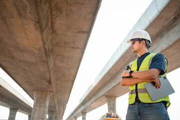 Asian civil engineer specialists examining trades at road construction site, industrial building construction site. Concrete skyscraper of road construction