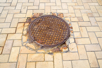 metal sewer manhole in pavement , close-up shot