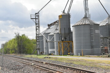 Fototapeta na wymiar Grain Bins by Railroad Tracks