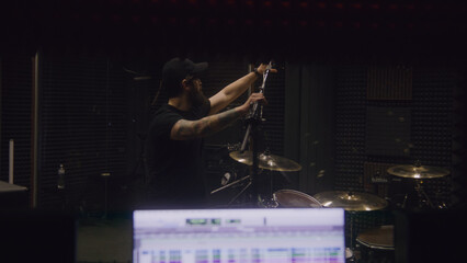 Sound engineer tunes musical instruments for recording album in music recording room. Computer...