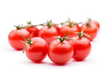 Small red cherry tomatoes on white background.