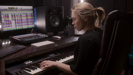 Female sound engineer, musician uses MIDI controller, digital electric piano for creating music....