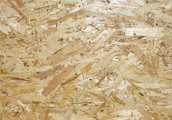 Oriented Strand Board. Chipboard building material. OSB wooden panel made of pressed sandy brown wood shavings as background front view