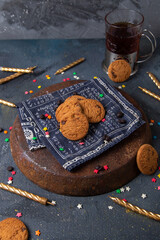front view delicious chocolate cookies with cup of tea and candles on the dark-grey background cookie biscuit sweet sugar tea
