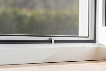 Mosquito net on the window to protect against insects close-up, fastening fragment