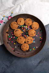 top distant view delicious chocolate cookies inside brown round plate on the white background cookie sweet tea
